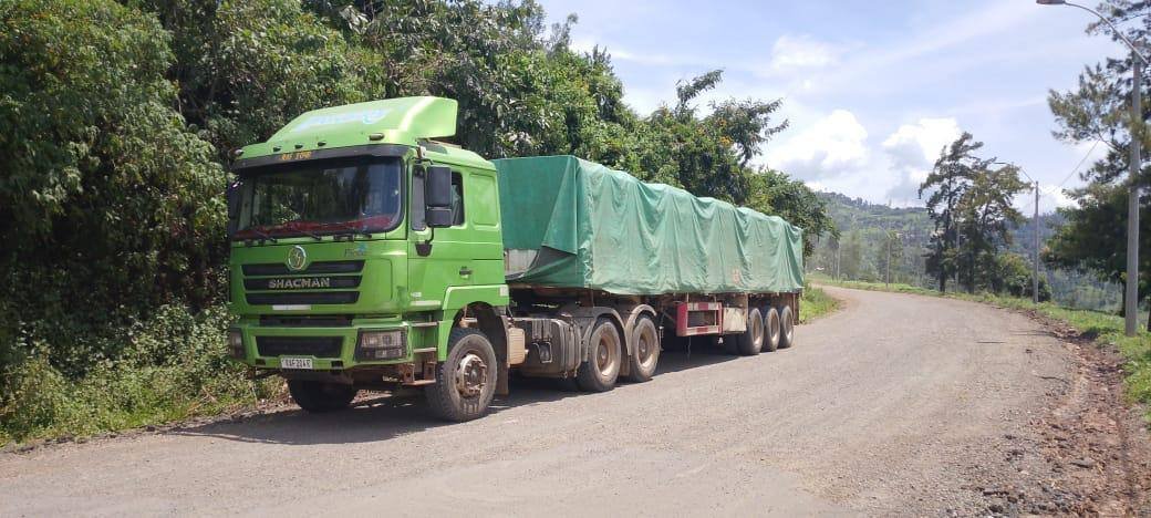 Megira long-haul truck and trailer loaded with tarped cargo on the road